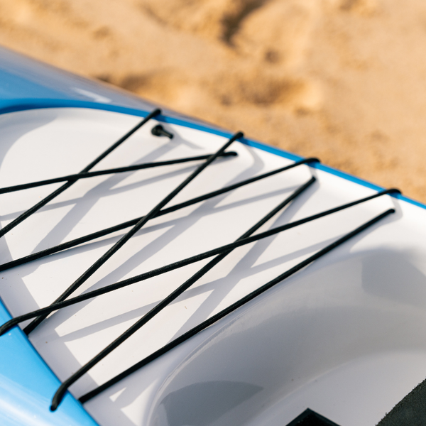 A technical close-up of a blue Synergy outrigger canoe from the Nalu collection, highlighting the black heavy-duty bungee cargo netting on the rear deck.