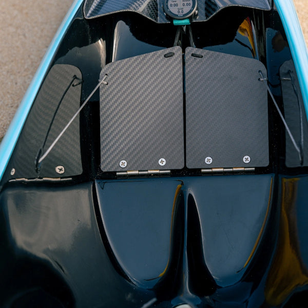 A detailed close-up of the adjustable carbon fiber steering foot pedals inside the Supernova High Performance Canoe Collection cockpit.