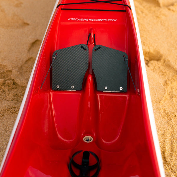 Interior view of the red cockpit showing black carbon fiber foot pedals and "Autoclave Pre-Preg Construction" branding.